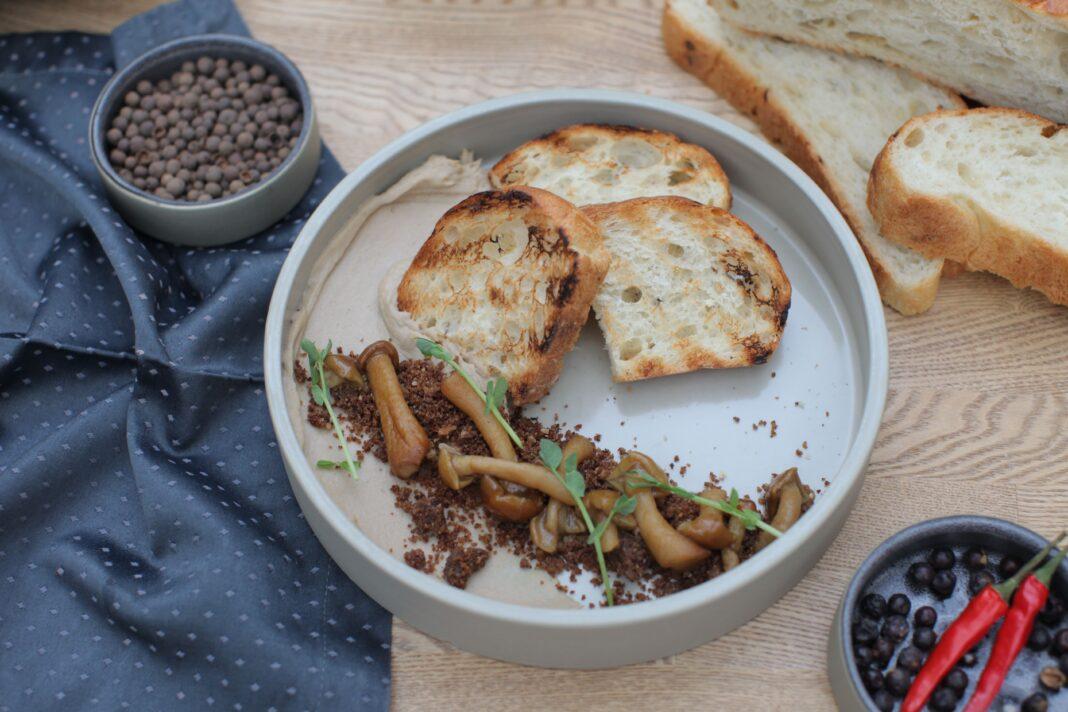 Delicious gourmet breakfast featuring toasted bread with mushrooms and fresh herbs.