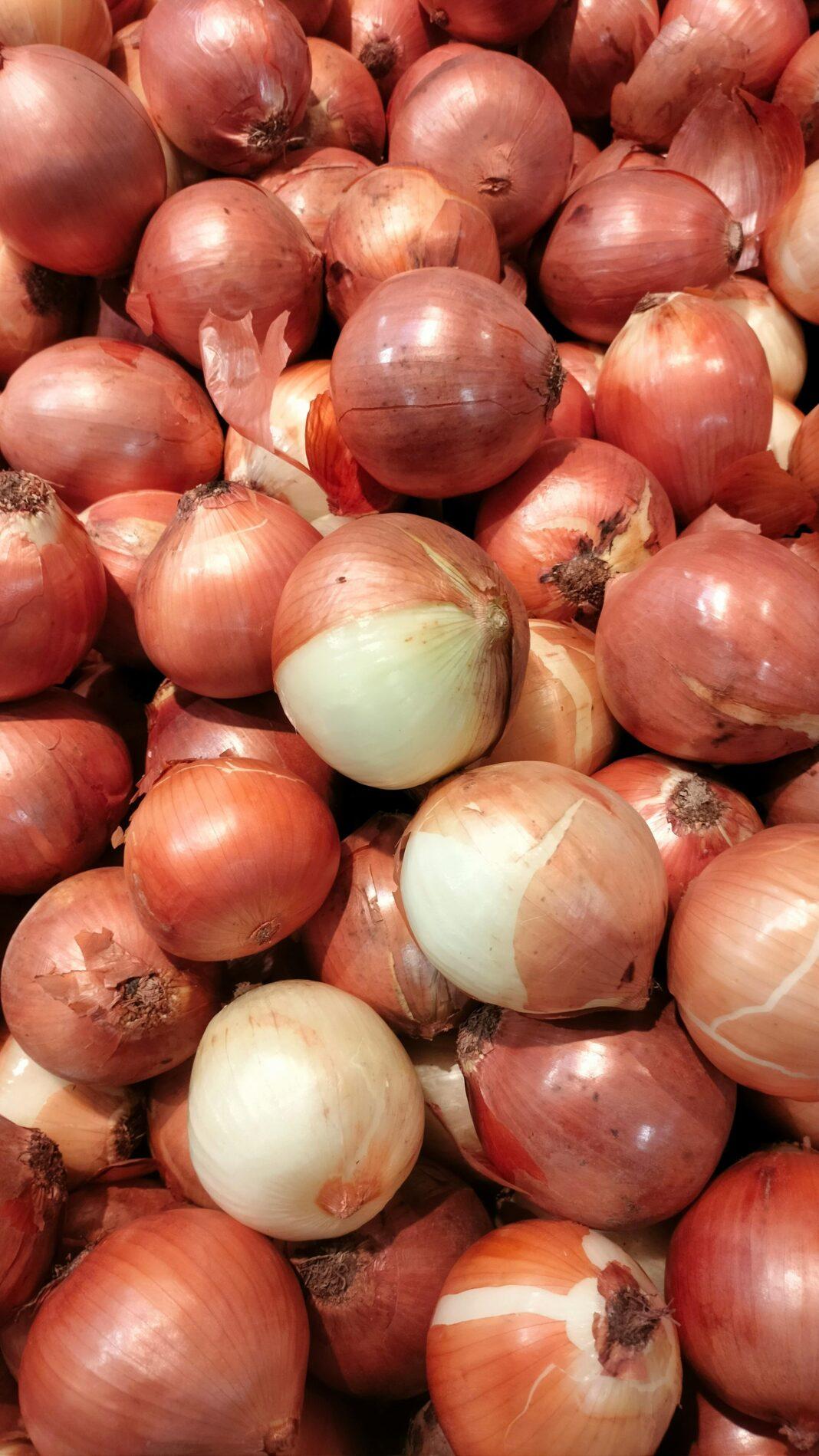 A vibrant pile of fresh red and white onions at a local market.