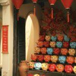 Menu Nouvel An 2019 Célébration Année du Cochon sans Porc Vibrant display of red lanterns and pig figurines in an outdoor shop setting.
