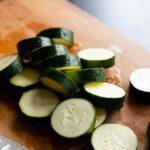 Courgette rapide et delicieuse Recettes soupe frittata et courgettes farcies Close-up of sliced zucchini on a wooden cutting board for food preparation.