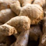 Detailed view of fresh raw ginger roots, showcasing texture and earthy tones. Ideal for food themes.