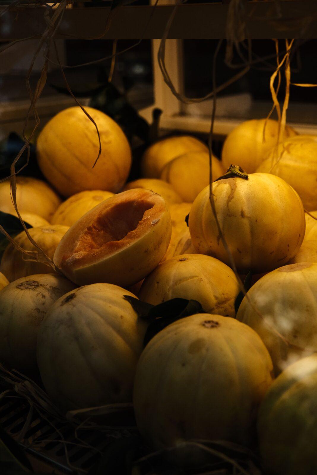 Yellow melons displayed in a market setting, showcasing fresh produce.