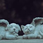 Stone cat and dog with wings add whimsical charm to any garden decor.