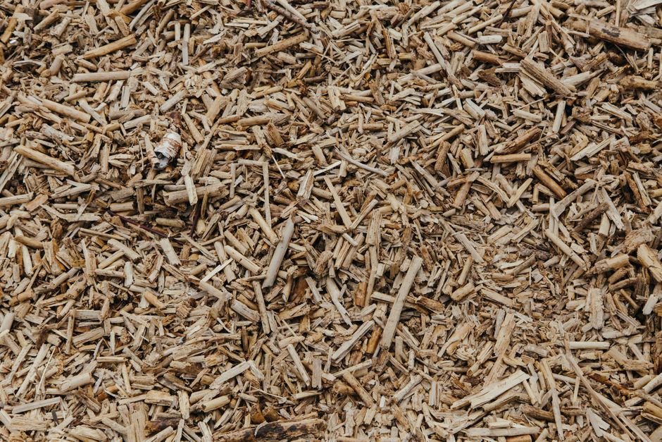 Close-up view of a textured surface of natural brown wood chips, ideal for organic and environmental themes.