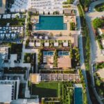 Piscine au jardin en 2026 : déclaration, PLU et sécurité, sans plongeon administratif Stunning birds-eye view of a luxurious resort featuring lush gardens and sparkling pools.