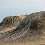 Taupes au jardin : 5 gestes avant le piège, campagnol compris Close-up view of dry mud mounds in a natural barren landscape, showcasing rugged textures.