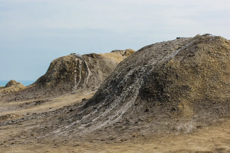 Close-up view of dry mud mounds in a natural barren landscape, showcasing rugged textures.