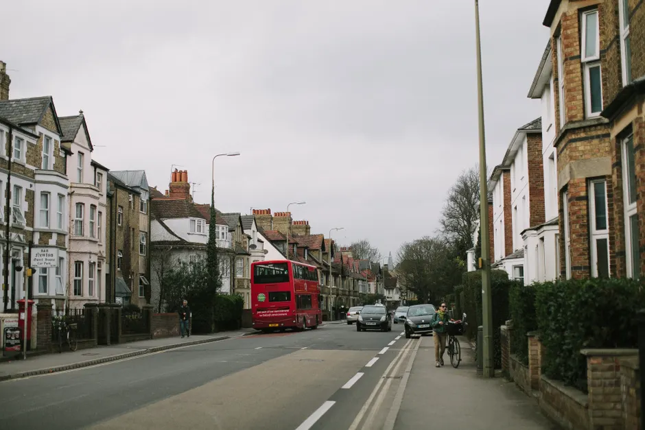 Quintessential Oxford street scene with iconic red double-decker bus and historic buildings.