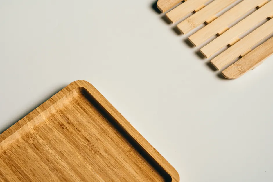 Stylish bamboo tray and slatted wooden decor piece on white surface.