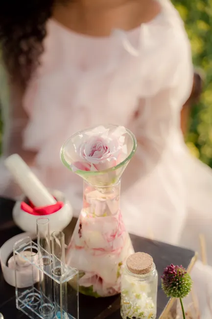 Stylish floral display with rose petals in glassware on a table, promoting a feminine aesthetic.