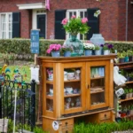 Armoire de jardin en bois : 15 mm de volige, sans feeling Vintage outdoor cabinet with plants and decor for sale in a garden setting.